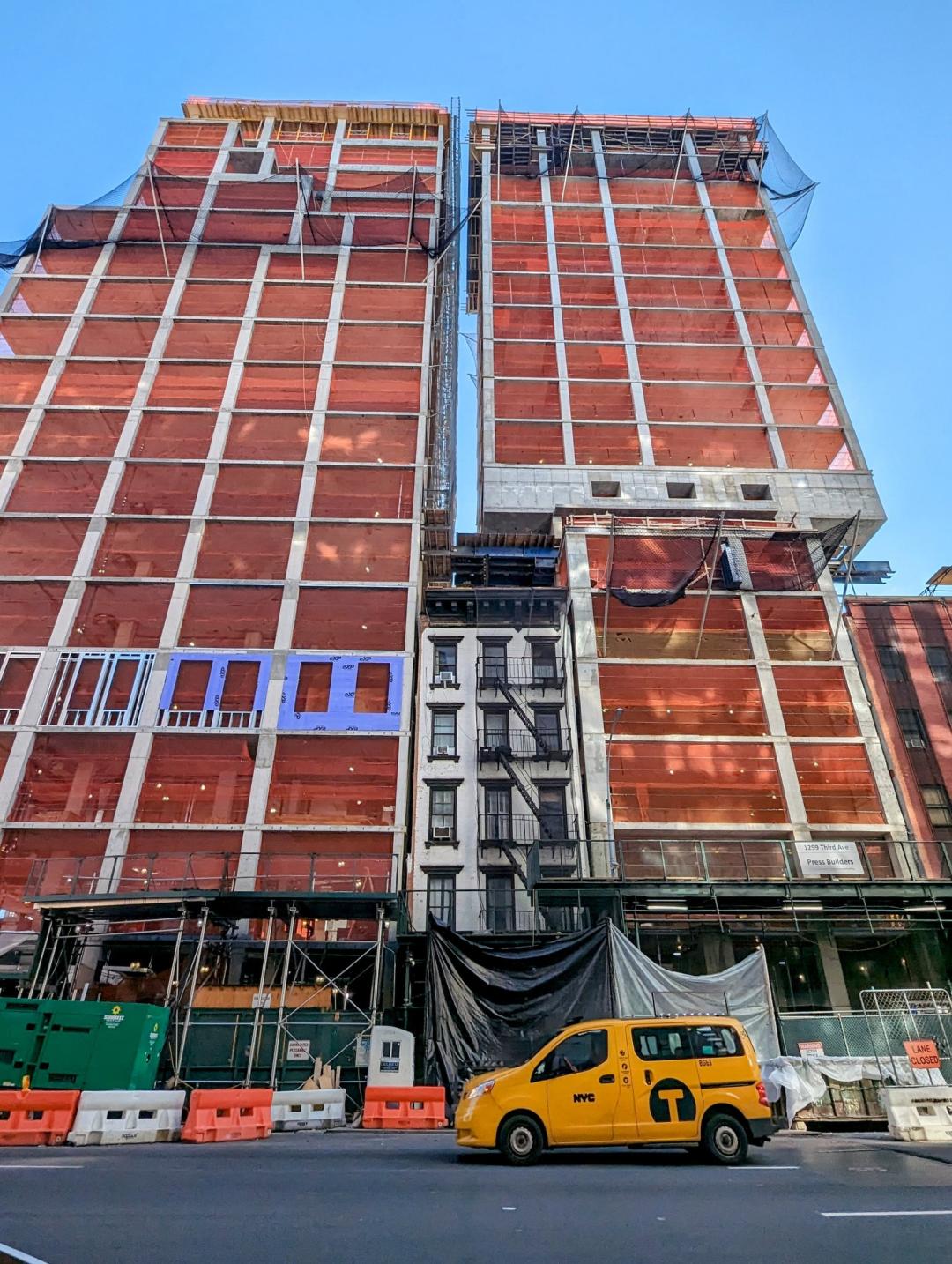 NYC Construction with a new building being build around and overtop an old apartment building