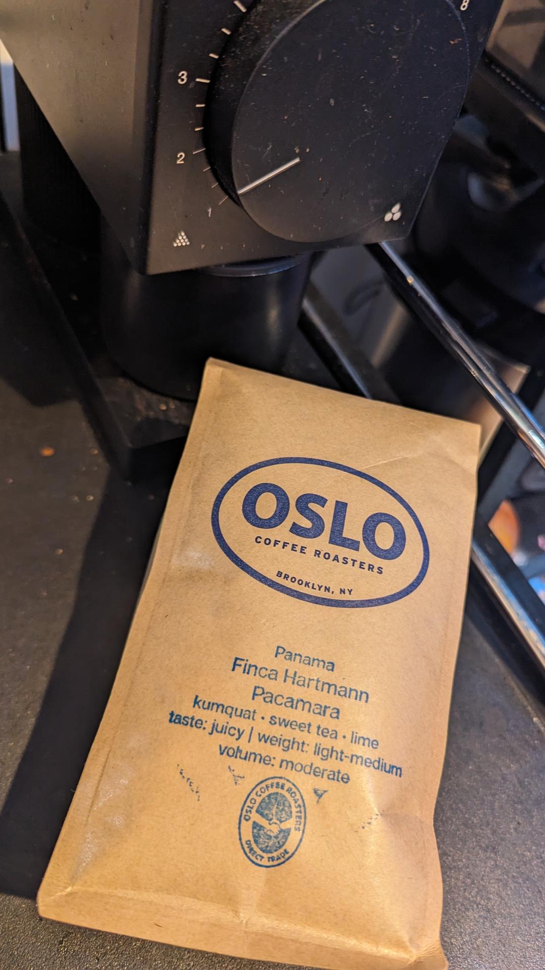 A bag of Oslo Coffee Roaster beans. A brown bag with the Oslo logo and bean type stamps in blue ink.