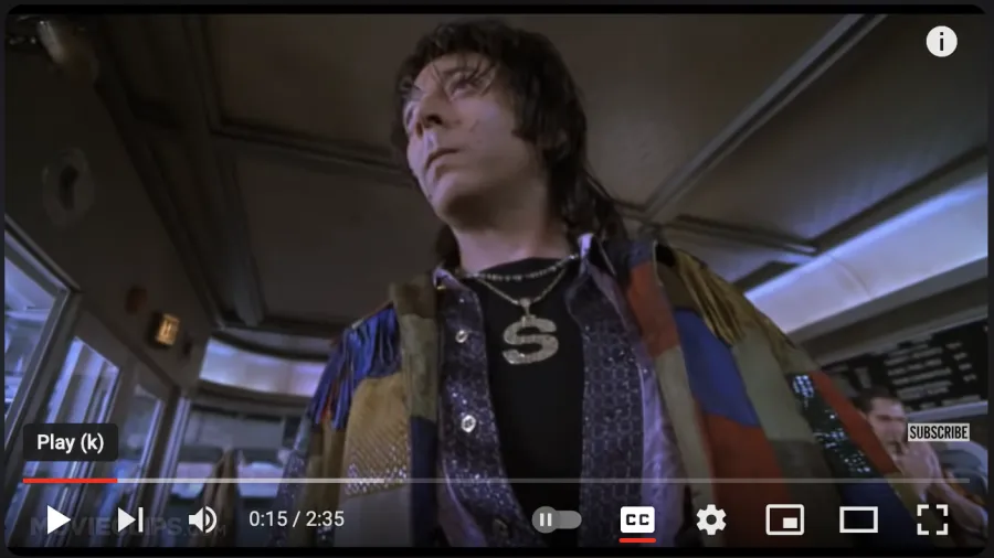 A thumbnail of the youTube video,  Paul Reubens as The Spleen, wearing patchwork clothing and poor complextion with zits