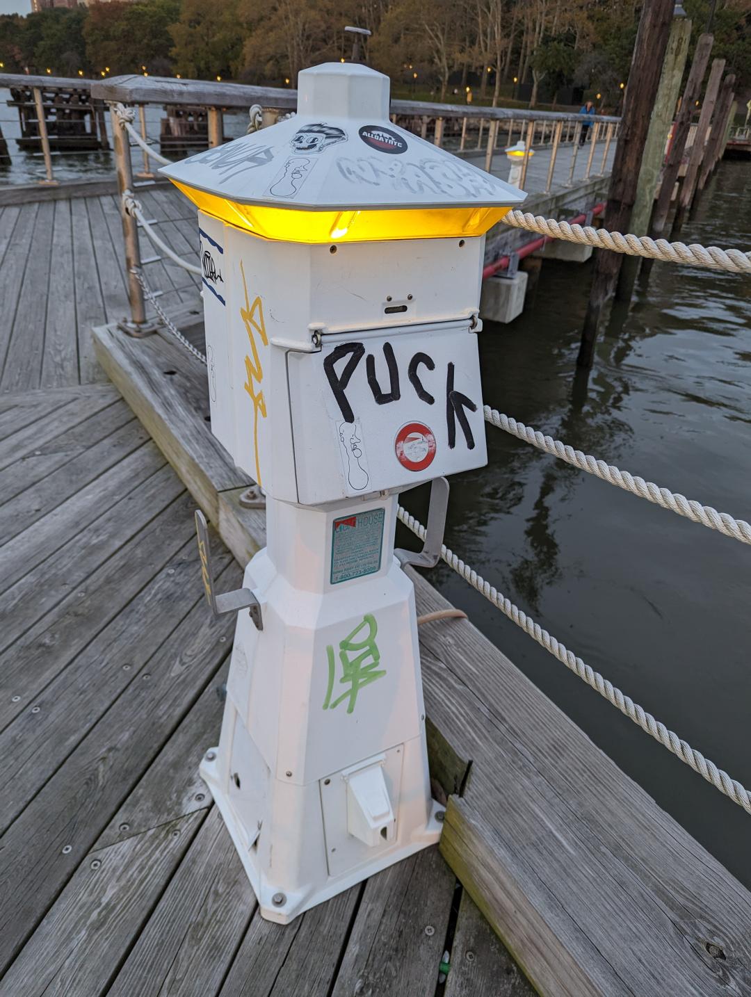 A unique lattern on a dock with graffati reading "Puck"
