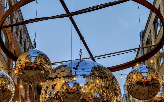 A photo of large outdoor disco balls at sunset taken in Brooklyn