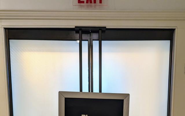 A sign blocking an exit in the New York City Museum, instructing you to exit via the shop